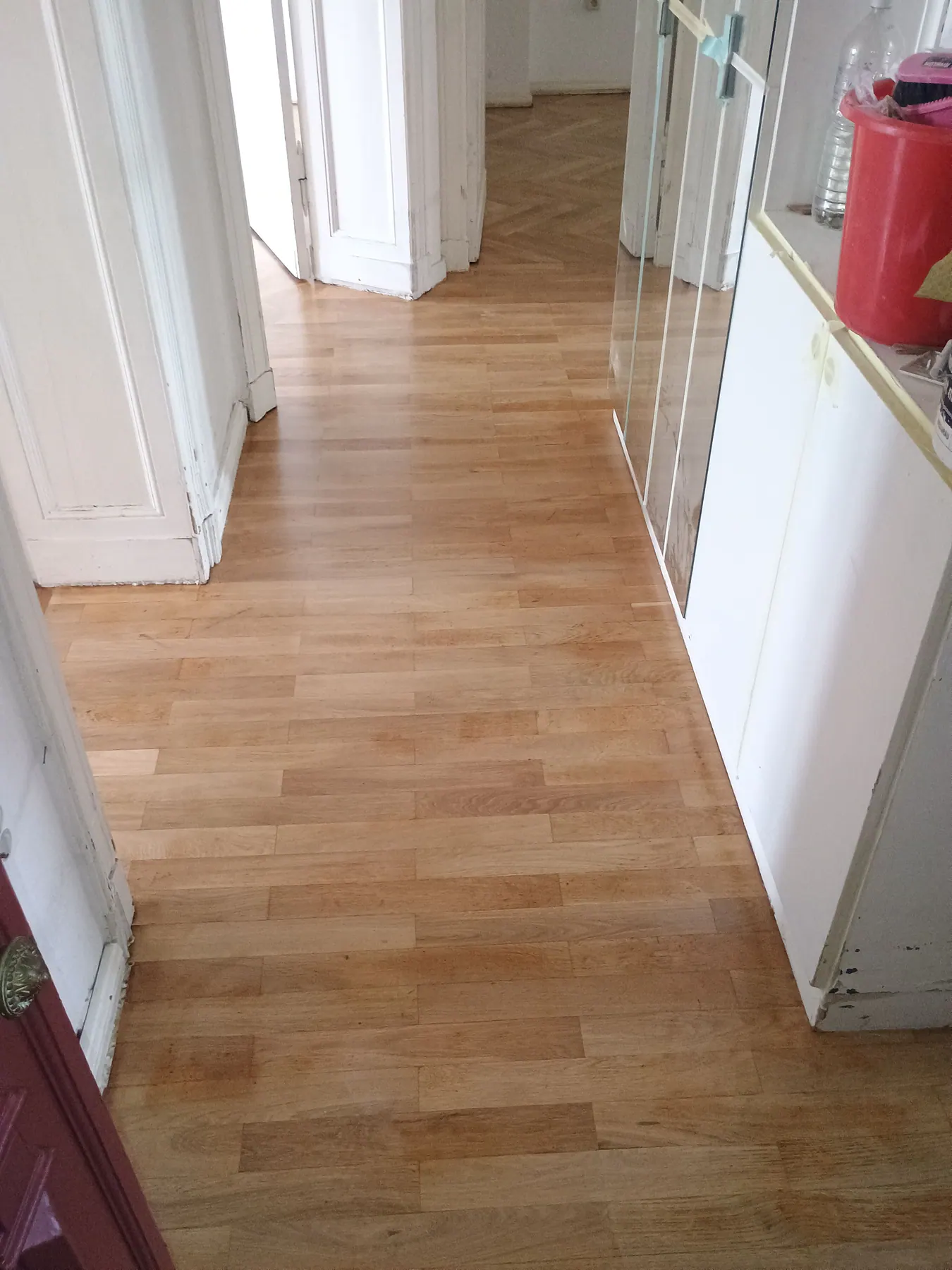 Aufgearbeiteter Holzboden im Flur mit mehreren Türöffnungen